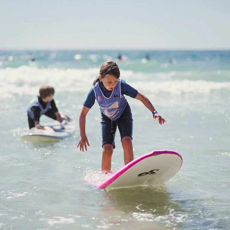 Une fille tient debout sur sa planche de surf.