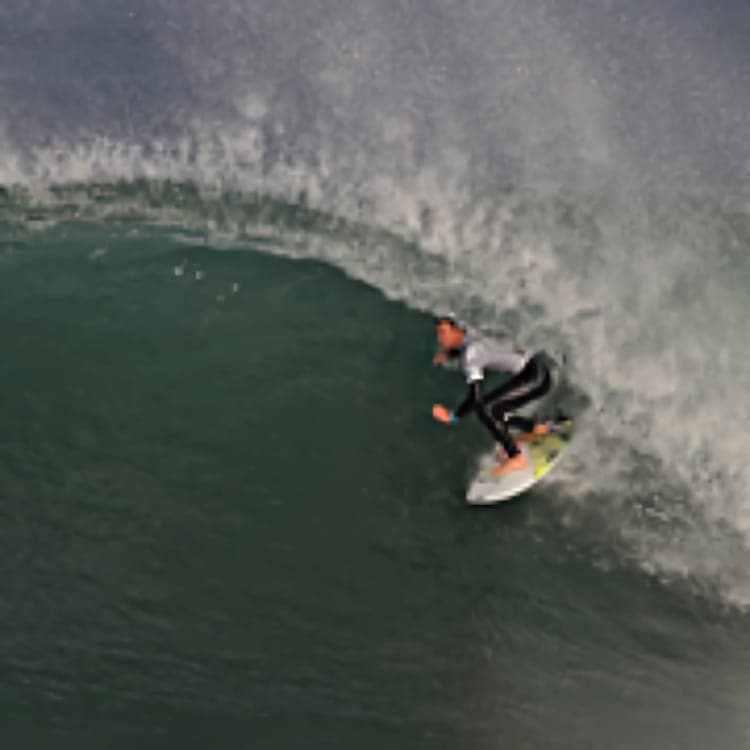 Un homme surfe dans une vague en tube à l’automne.
