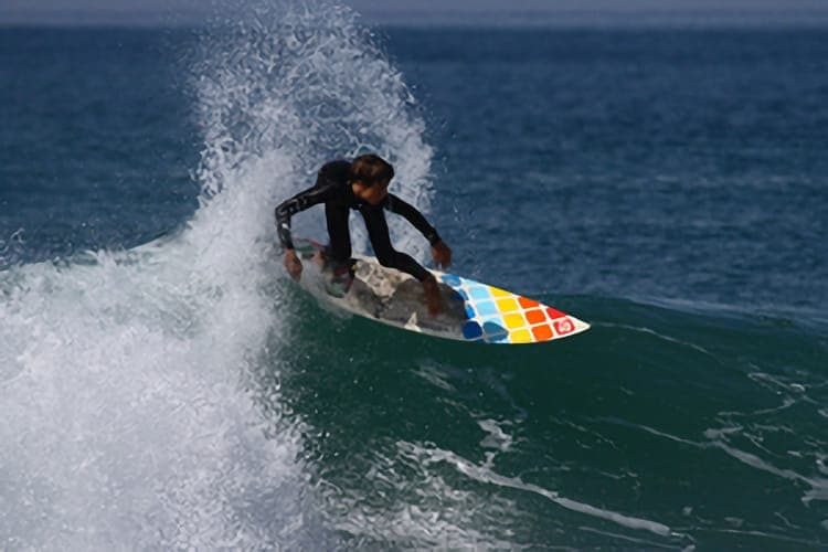Un adolescent en combinaison surfe sur une vague au printemps